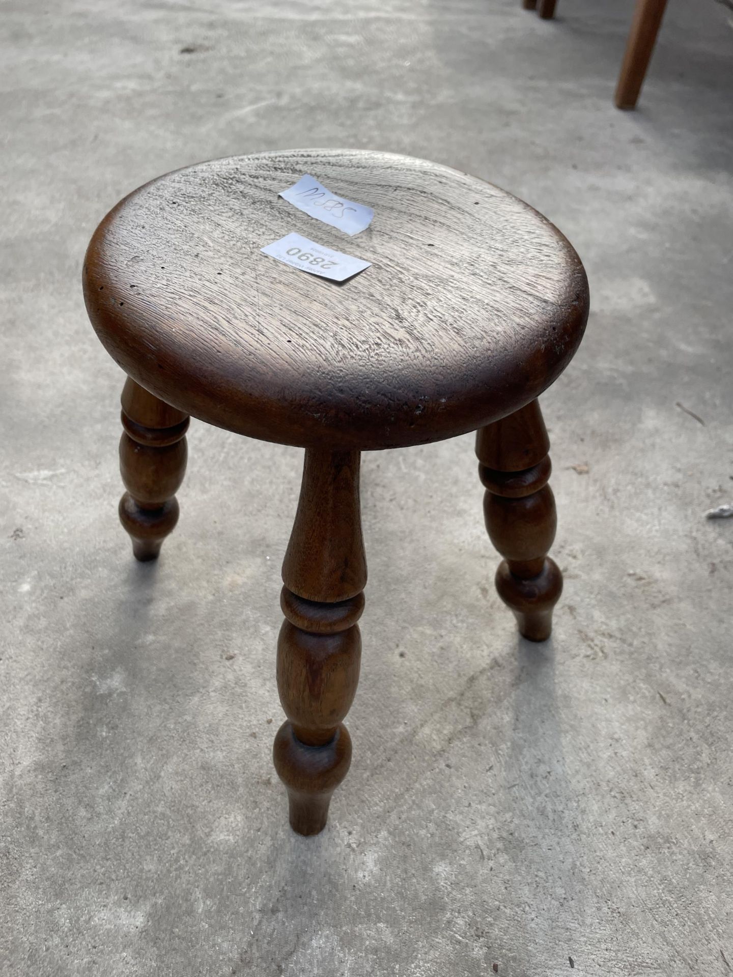 A SMALL ELM STOOL ON TURNED LEGS