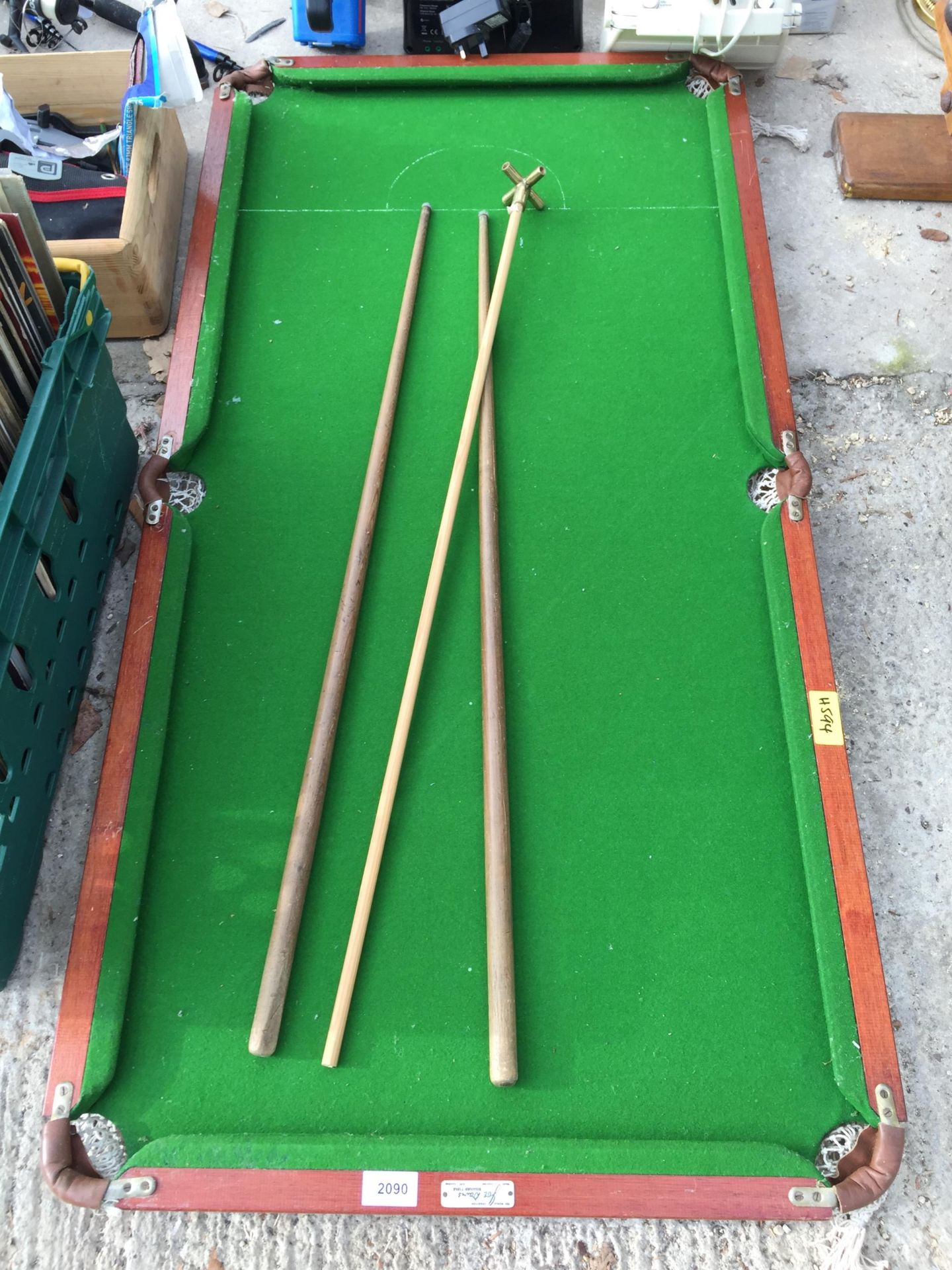 A SMALL TABLE TOP SNOOKER TABLE WITH TWO CUES AND A REST