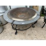 A LARGE CIRCULAR GARDEN FIRE PIT WITH GRANITE STYLE SURROUND AND METAL BASE