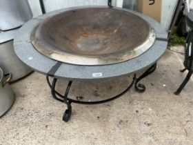 A LARGE CIRCULAR GARDEN FIRE PIT WITH GRANITE STYLE SURROUND AND METAL BASE