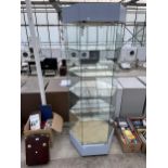 A HEXAGONAL GLASS SHOP DISPLAY UNIT WITH SHELVES