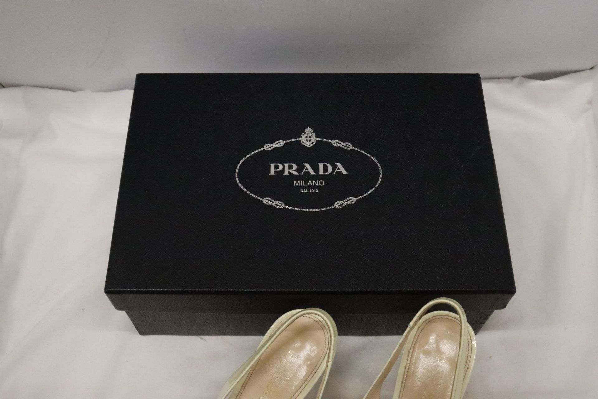 A PAIR OF CREAM HIGH HEELED SHOES, MARKED WITH A GOLD COLOURED 'PRADA' TO THE UNDERSIDE, IN A BOX - Image 2 of 7