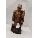 A LARGE HAND CARVED WOODEN HUNTER GATHERER