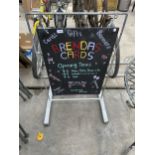 A SWINGING BLACKBOARD SIGN WITH METAL FRAME AND STAND