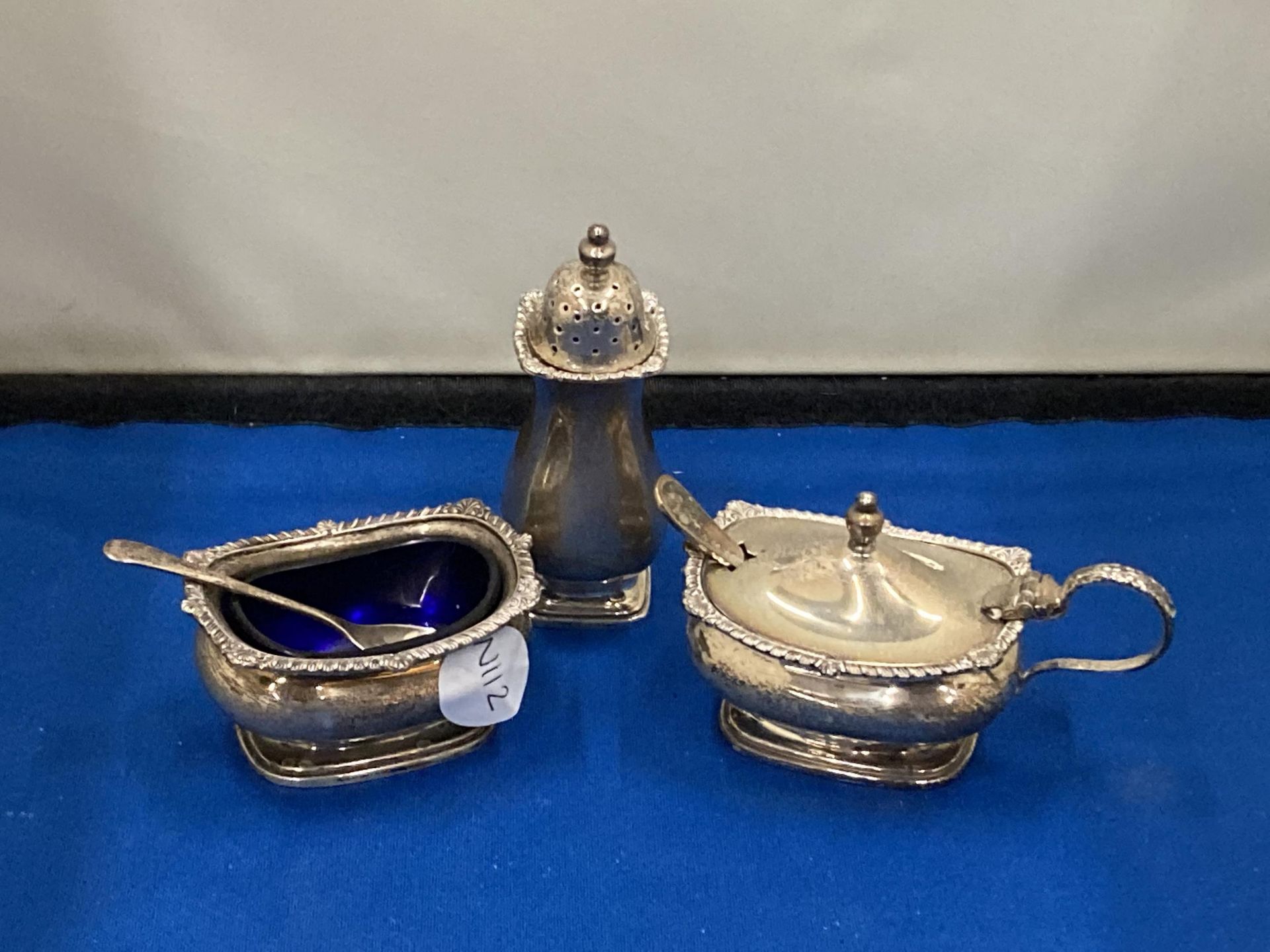 A HALLMARKED BIRMINGHAM SILVER CONDIMENT SET TO INCLUDE A BLUE GLASS LINED SALT AND LIDDED MUSTARD
