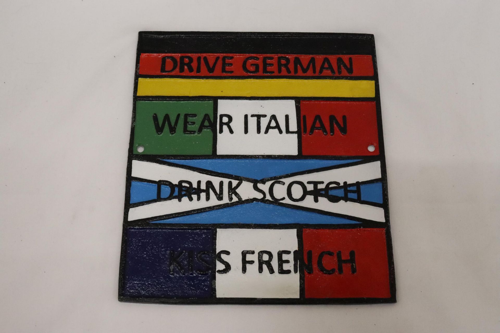 A CAST SIGN, 'DRIVE GERMAN, WEAR ITALIAN, DRINK SCOTCH, KISS FRENCH', 23CM X 26CM