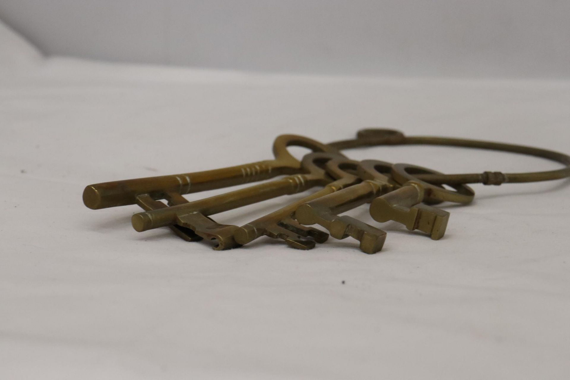 A SET OF LARGE VINTAGE STYLE BRASS KEYS ON A RING HOLDER - Image 2 of 4