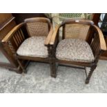 A PAIR OF EARLY 20TH CENTURY OAK TUB CHAIRS WITH CANE SEATS AND BACKS ON BARLEY TWIST LEGS AND