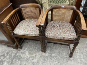 A PAIR OF EARLY 20TH CENTURY OAK TUB CHAIRS WITH CANE SEATS AND BACKS ON BARLEY TWIST LEGS AND