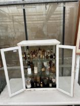 A VINTAGE APOTHECARY CABINET CONTAINING A LARGE ASSORTMENT OF VINTAGE GLASS MADICINE BOTTLES