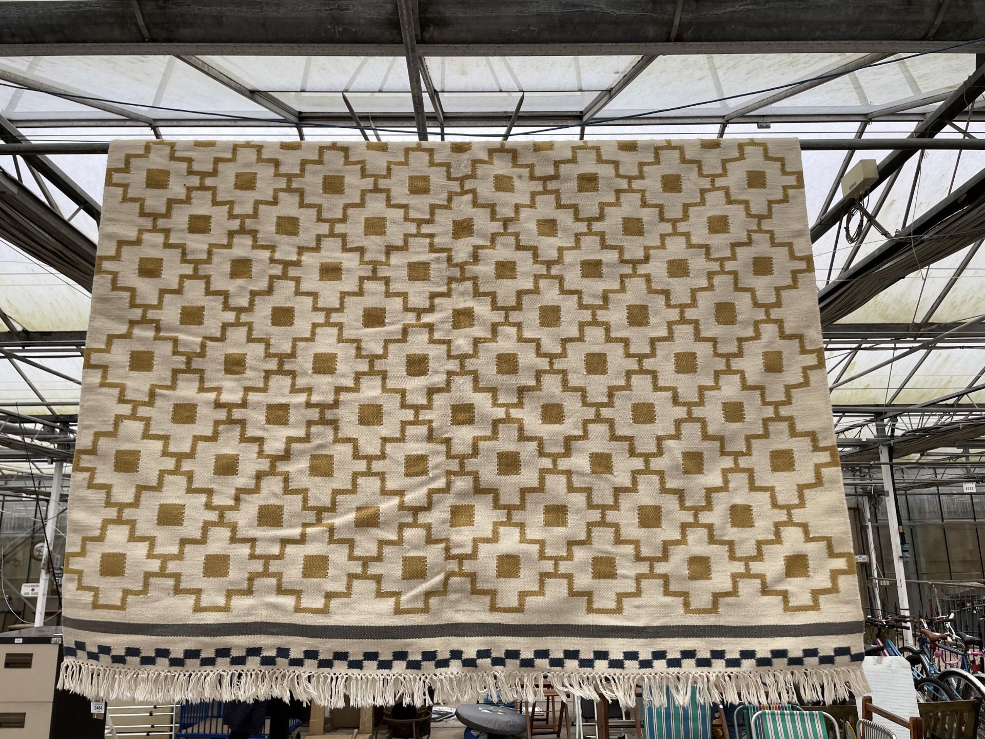 A MODERN CREAM PATTERNED FRINGED RUG