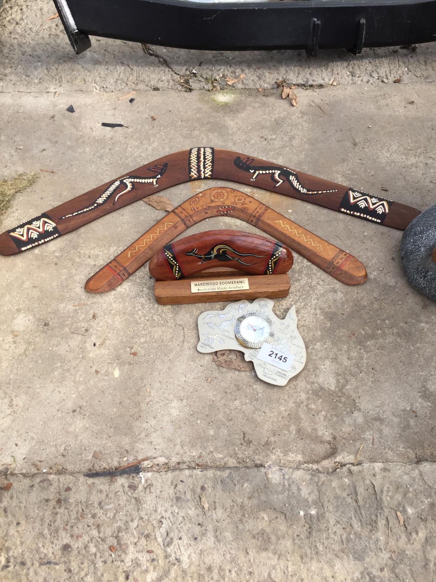 THREE WOODEN BOOMERANGS AND A CLOCK SET IN A MAP OF AUSTRALIA