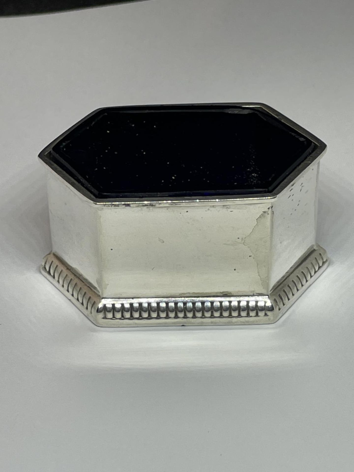 A CHESTER HALLMARKED WALKER AND HALL HEXAGONAL SALT WITH BLUE GLASS LINER