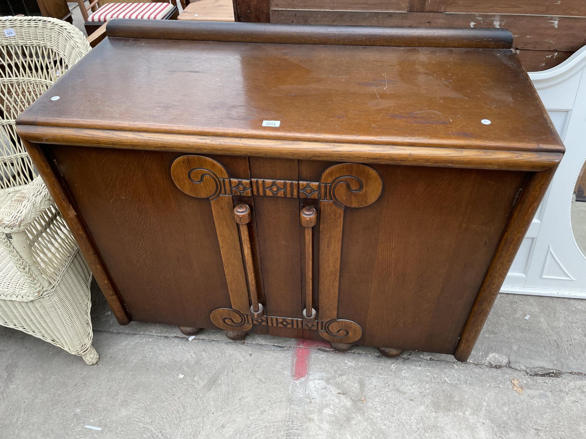 AN OAK ART DECO SIDEBOARD, 48" WIDE WITH LONG DROP TURNED TWIN HANDLES