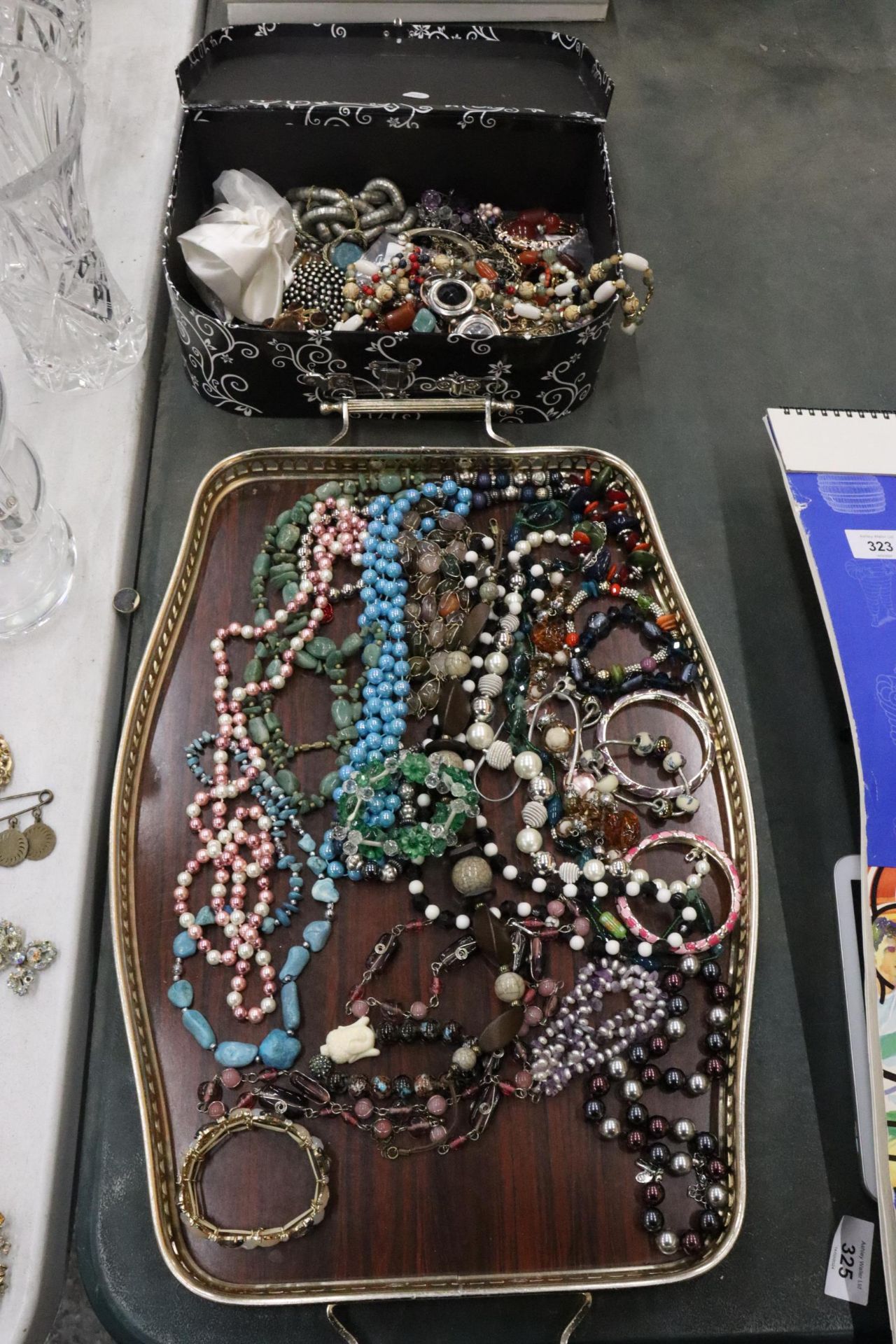 A QUANTITY OF COSTUME JEWELLERY TO INCLUDE NECKLACES, BRACELETS, BEADS, BROOCHES, ETC, WITH A VANITY