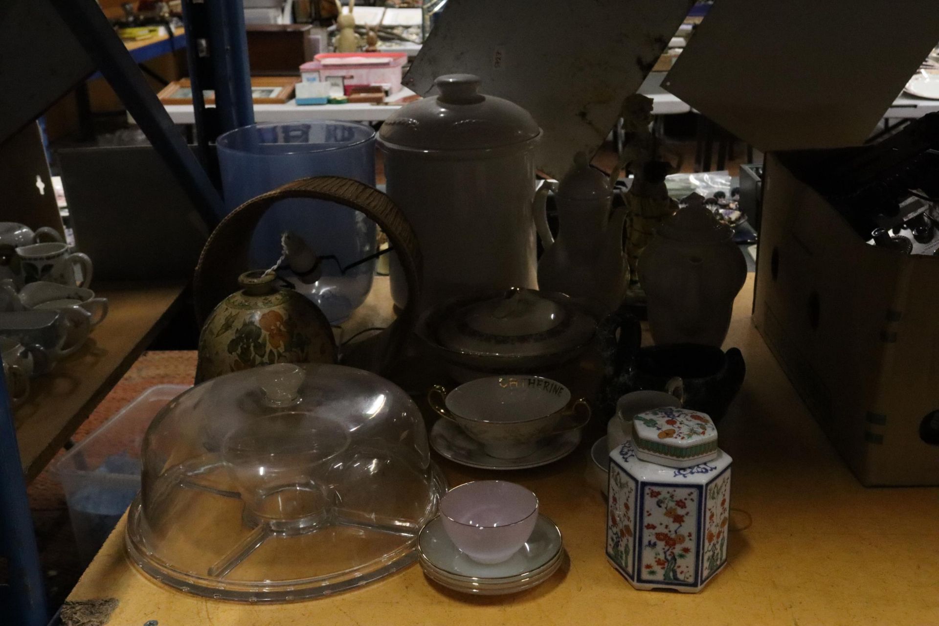 A LARGE MIXED LOT TO INCLUDE, COFFEE POTS, A BREAD CROCK, CUPS AND SAUCERS, CAKE COVER, TABLE