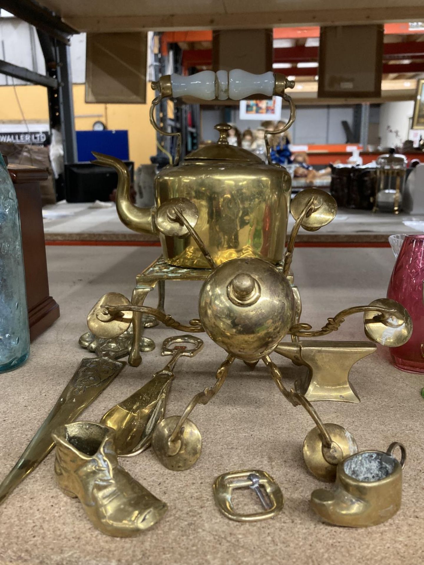 VARIOUS BRASS ITEMS TO INCLUDE A KETTLE WITH CERAMIC HANDLE ON A TRIVET, A SMALL ANVIL BOOT, ETC