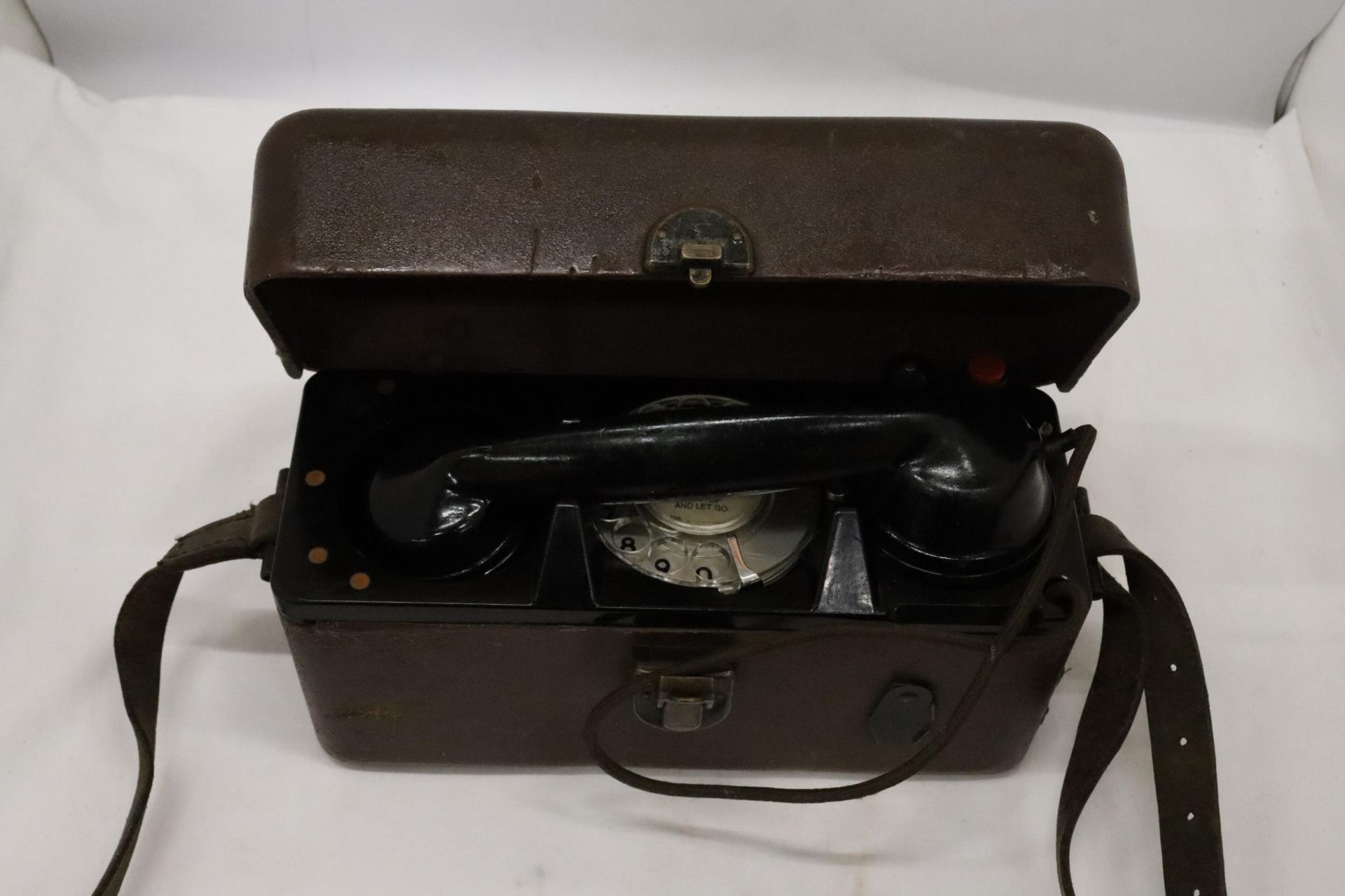 A WORLD WAR 11 MILITARY TELEPHONE IN A LEATHER CASE
