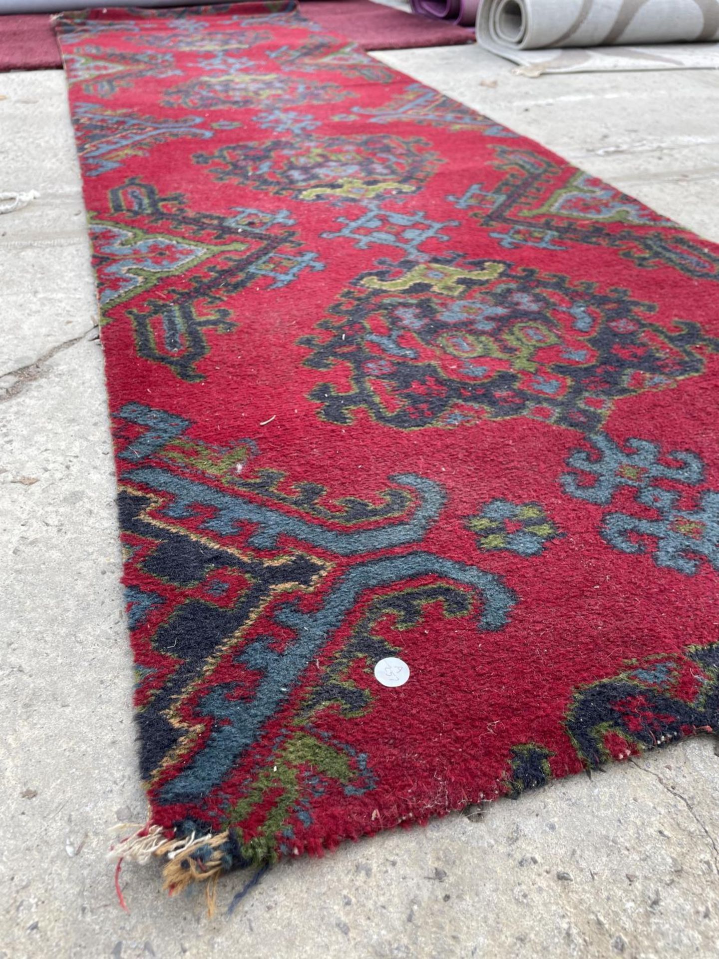 A SMALL RED PATTERNED RUG - Image 2 of 3