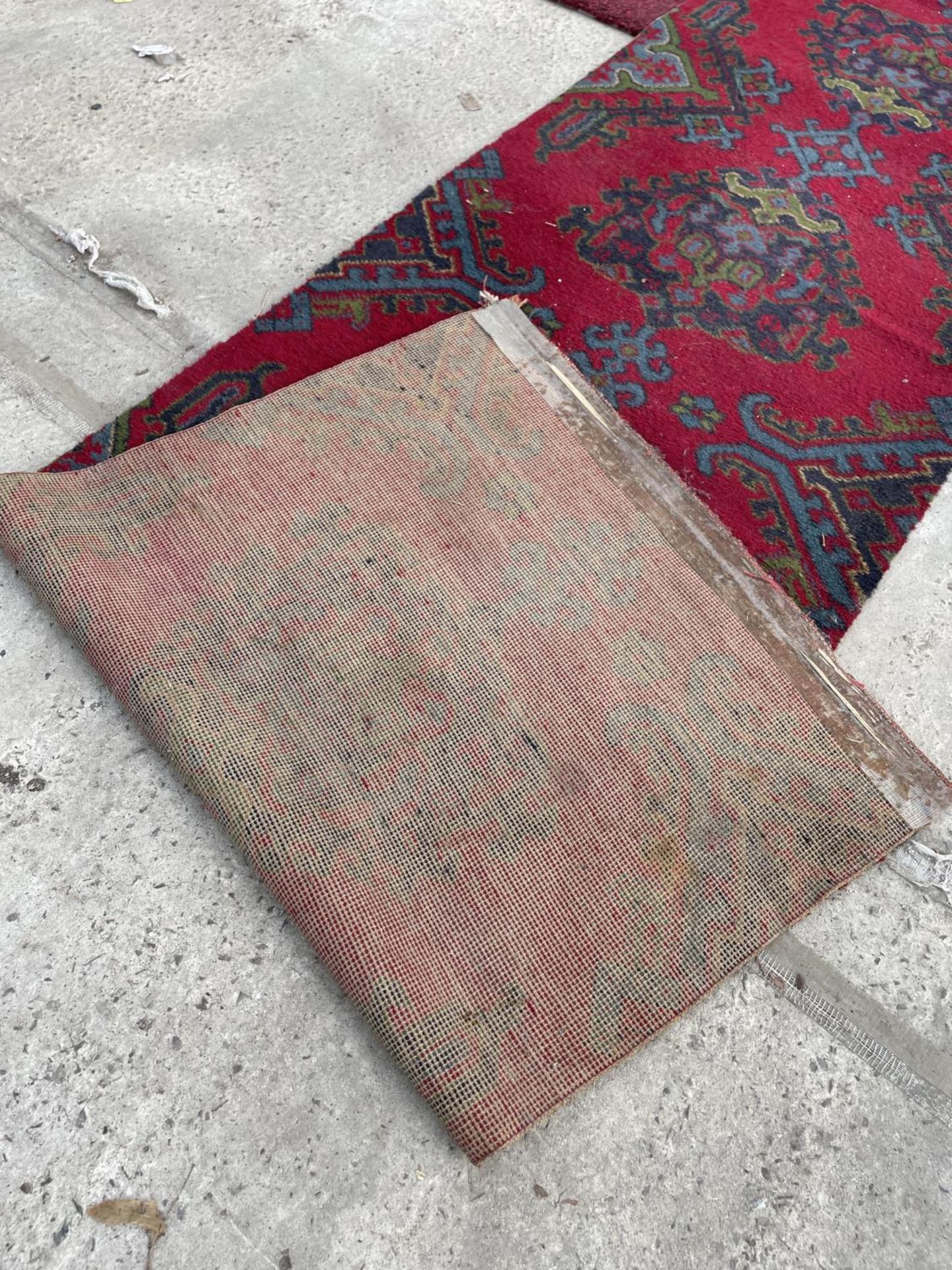 A SMALL RED PATTERNED RUG - Image 3 of 3