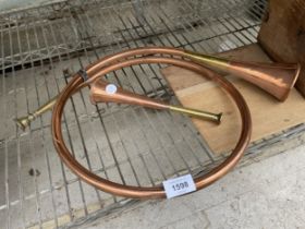 A SMALL COPPER AND BRASS HUNTING HORN AND A CURLED COPPER AND BRASS HORN