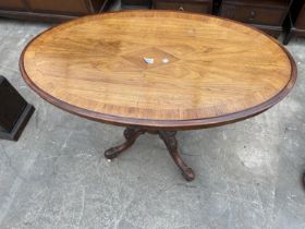 AN OVAL VICTORIAN WALNUT AND CROSSBANDED LOW TABLE ON TURNED LEGS