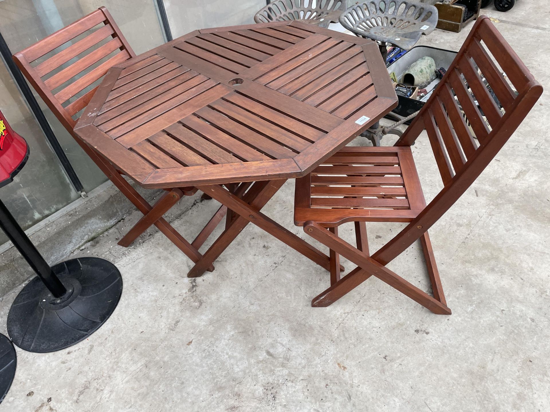 A WOODEN FOLDING PATIO TABLE AND TWO CHAIRS