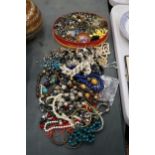 A LARGE QUANTITY OF COSTUME JEWELLERY TO INCLUDE BEADS, NECKLACES, BROOCHES, EARRINGS, ETC