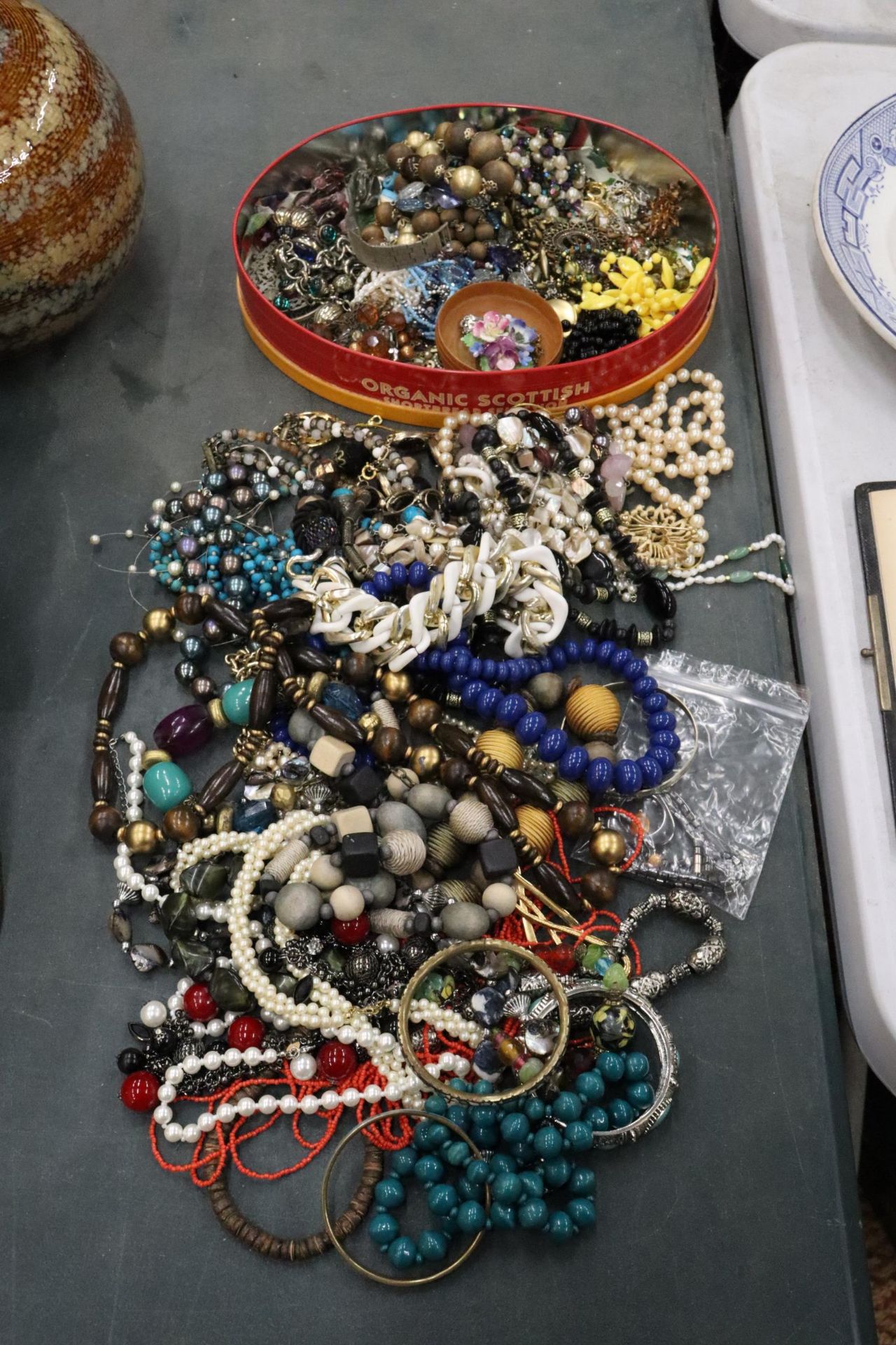 A LARGE QUANTITY OF COSTUME JEWELLERY TO INCLUDE BEADS, NECKLACES, BROOCHES, EARRINGS, ETC