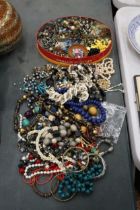 A LARGE QUANTITY OF COSTUME JEWELLERY TO INCLUDE BEADS, NECKLACES, BROOCHES, EARRINGS, ETC