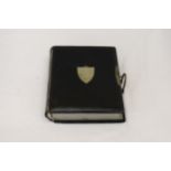 A VICTORIAN LEATHER BOUND PHOTO ALBUM WITH A WHITE METAL SHIELD SHAPED CARTOUCHE TO THE FRONT COVER