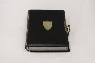 A VICTORIAN LEATHER BOUND PHOTO ALBUM WITH A WHITE METAL SHIELD SHAPED CARTOUCHE TO THE FRONT COVER