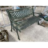 A WOOD SLATTED GARDEN BENCH WITH DECORATIVE CAST ENDS AND BACK