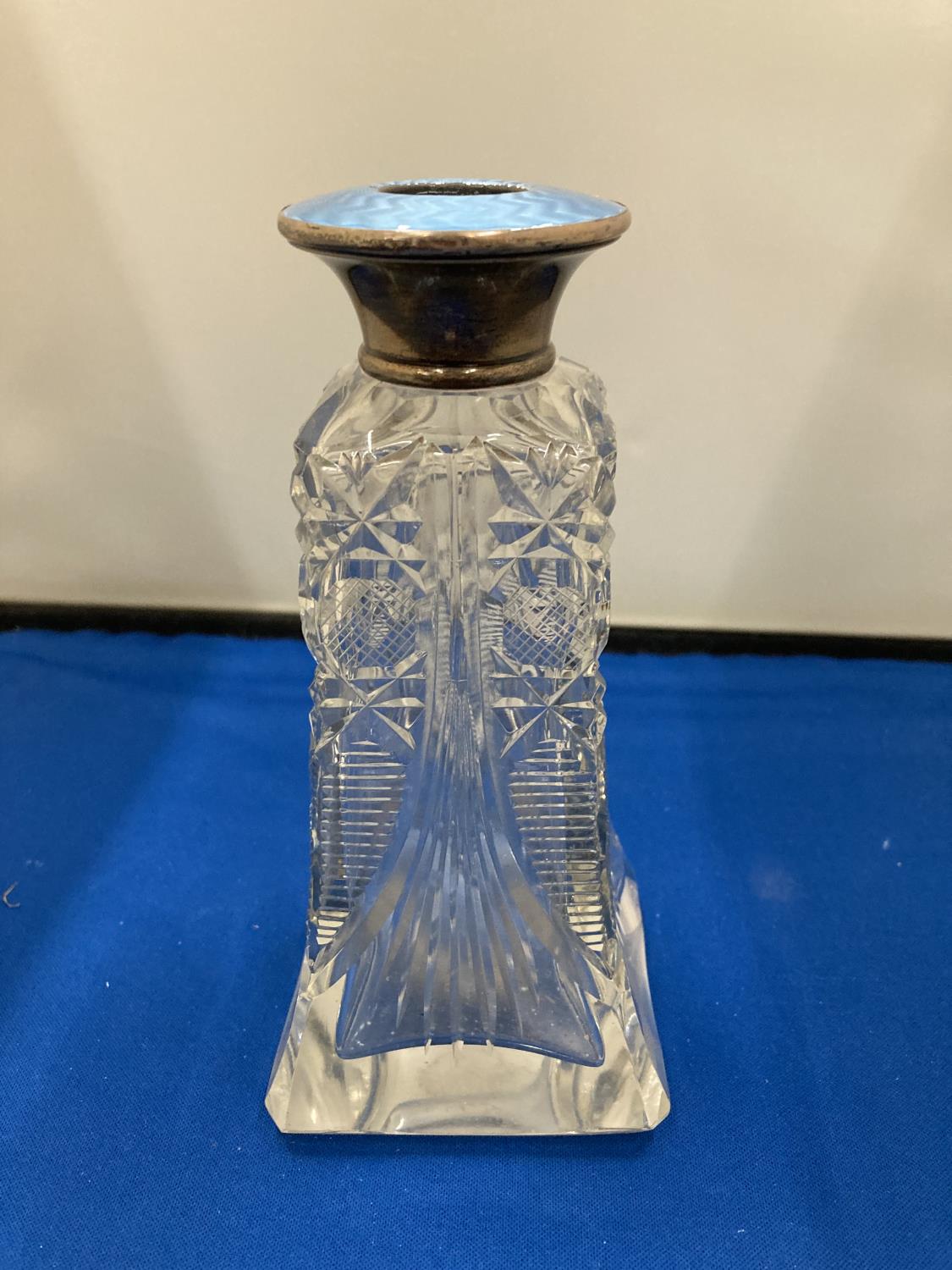 A CUT GLASS BOTTLE WITH A HALLMARKED LONDON SILVER PALE BLUE ENAMEL TOP