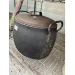 A VINTAGE CAST IRON COOKING POT WITH LID