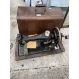 A VINTAGE JONES SEWING MACHINE WITH WOODEN CARRY CASE