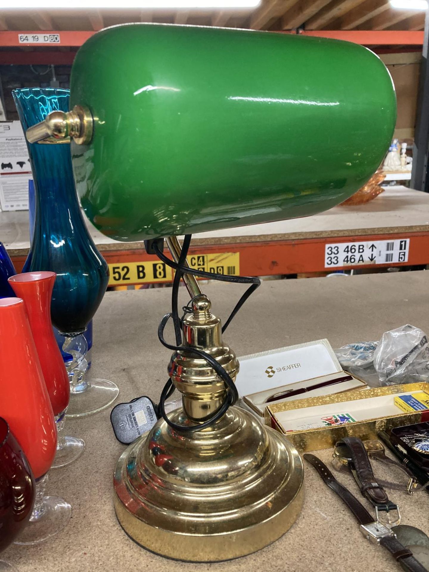 A BRASS BANKERS LAMP WITH A GREEN GLASS SHADE
