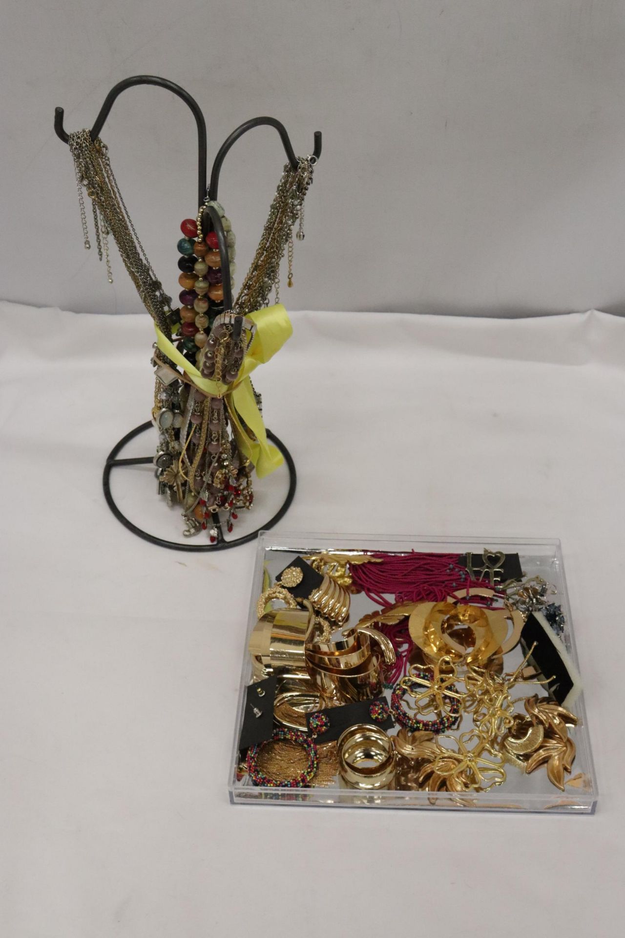 A JEWELLERY STAND WITH A QUANTITY OF NECKLACES PLUS A QUANTITY OF EARRINGS