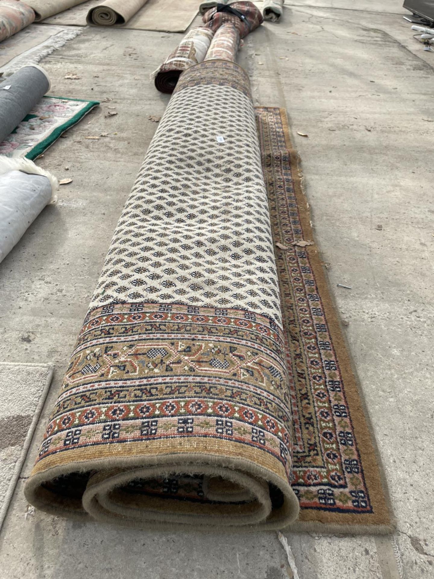 A LARGE ORANGE PATTERNED RUG