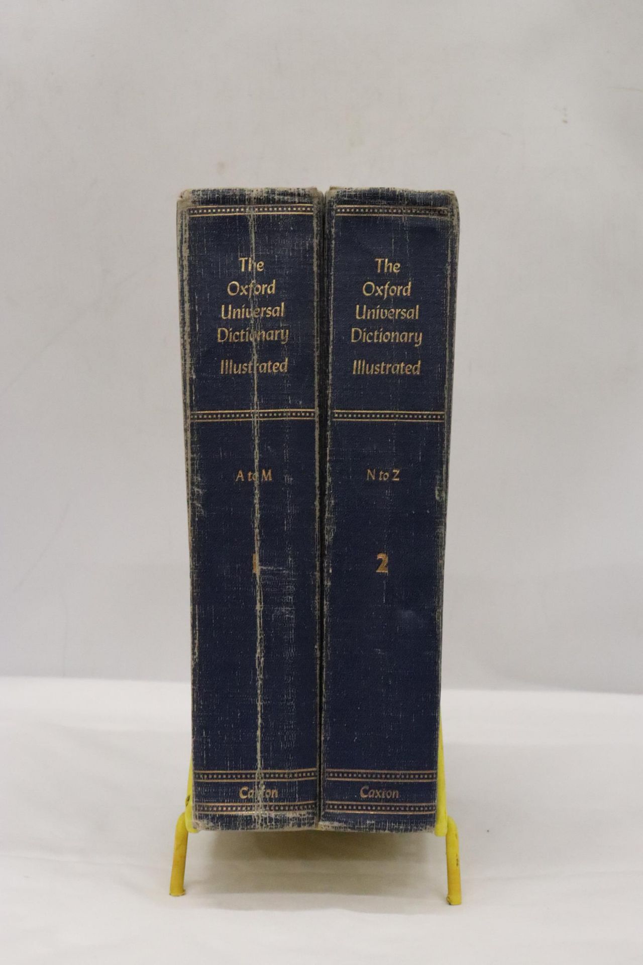 A PAIR OF OXFORD UNIVERSAL DICTIONARY'S IN METAL STAND