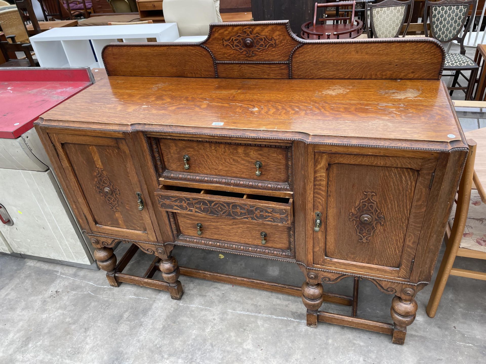 AN EARLY 20TH CENTURY OAK JACOBEAN STYLE BREAK FRONT SIDEBOARD WITH RAISED RACK, 60" WIDE