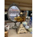 A VINTAGE OIL LAMP WITH AMBER GLASS RESERVOIR AND A DECORATIVE DRESSING TABLE MIRROR