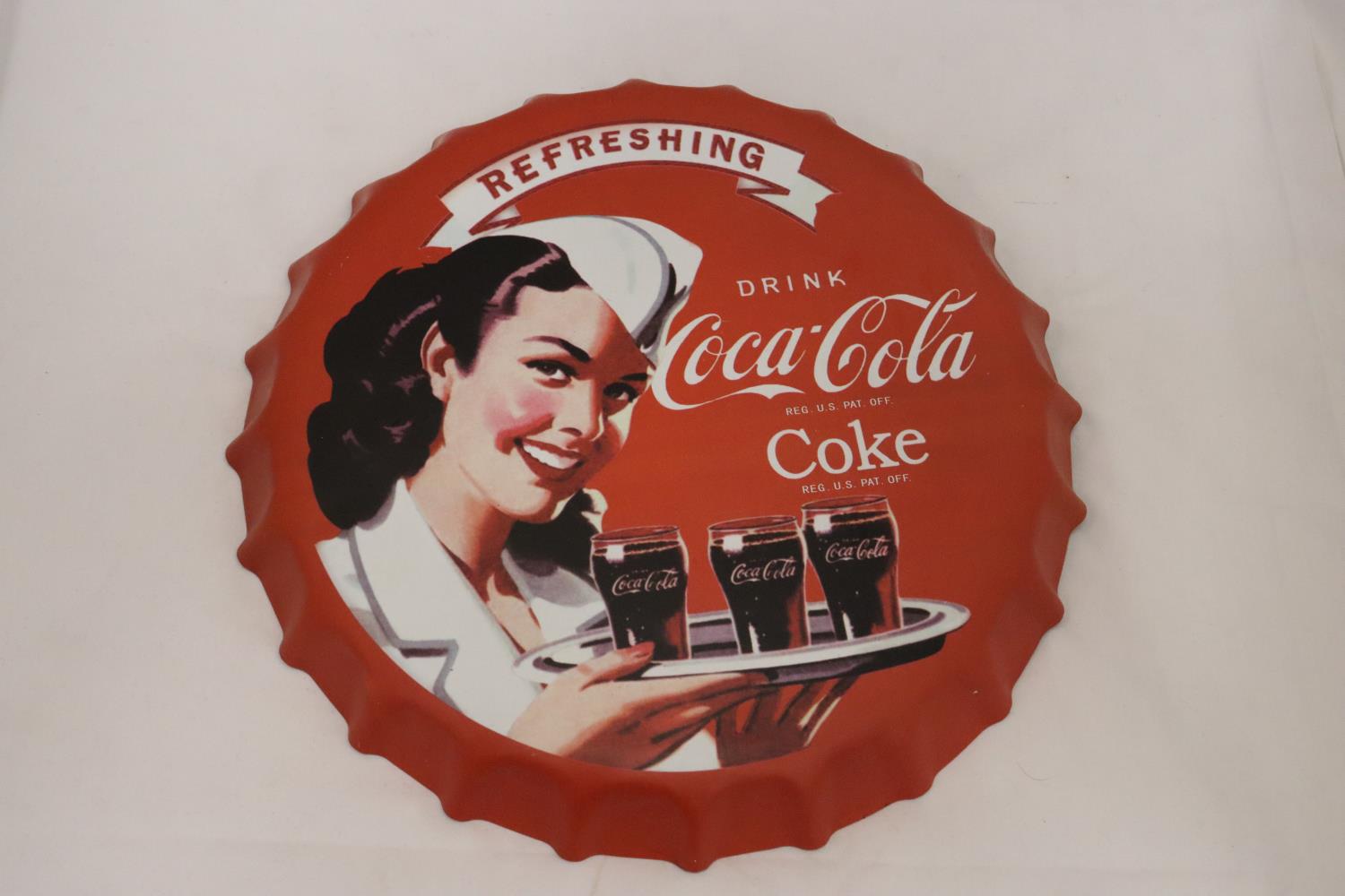 A LARGE COCA-COLA METAL BOTTLE TOP ADVERTISING PLAQUE