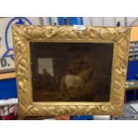 A GILT FRAMED OIL ON BOARD OF A HORSE IN A STABLE