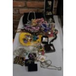 A QUANTITY OF COSTUME JEWELLERY TO INCLUDE NECKLACES, BEADS, EARRINGS, BROOCHES, ETC