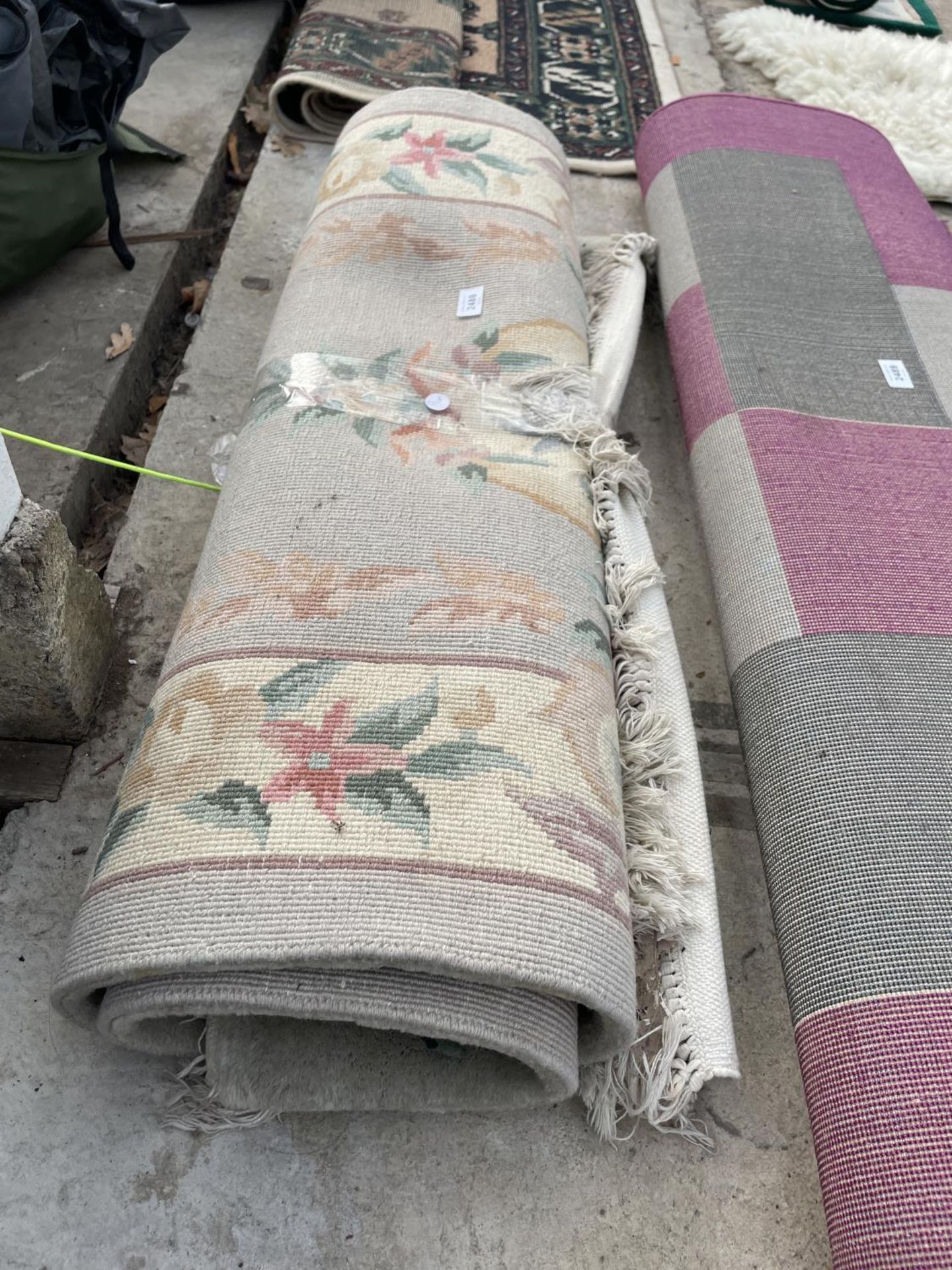 A SMALL GREEN PATTERNED FRINGED RUG