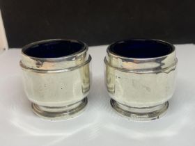 A PAIR OF HALLMARKED BIRMINGHAM SILVER SALTS WITH BLUE GLASS LINERS