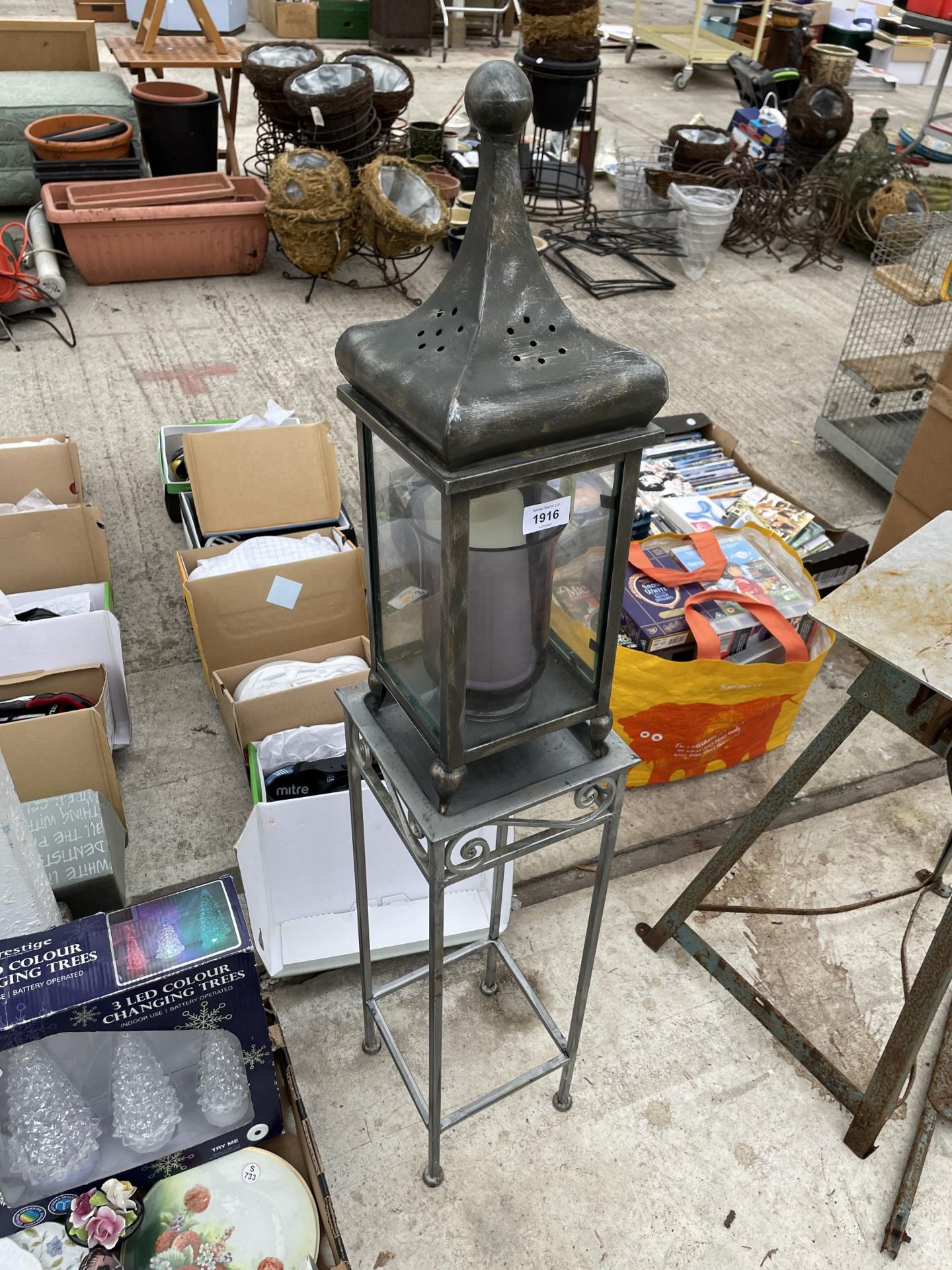 A METAL JARDINAIRE STAND WITH A METAL CANDLE LANTERN