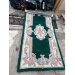 A SMALL GREEN PATTERNED RUG