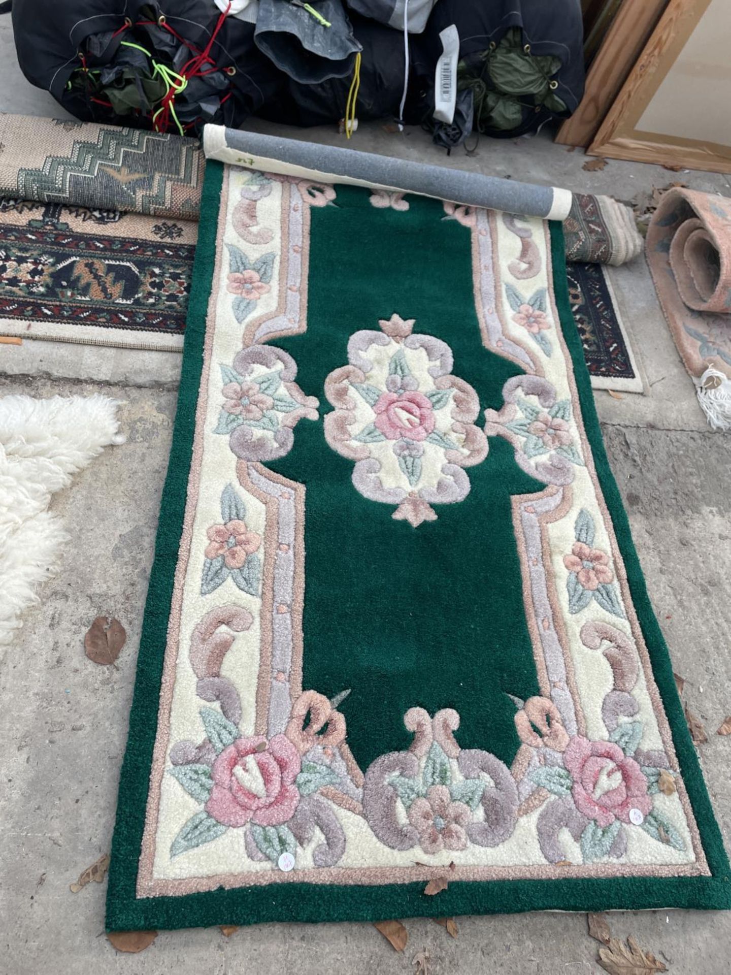 A SMALL GREEN PATTERNED RUG